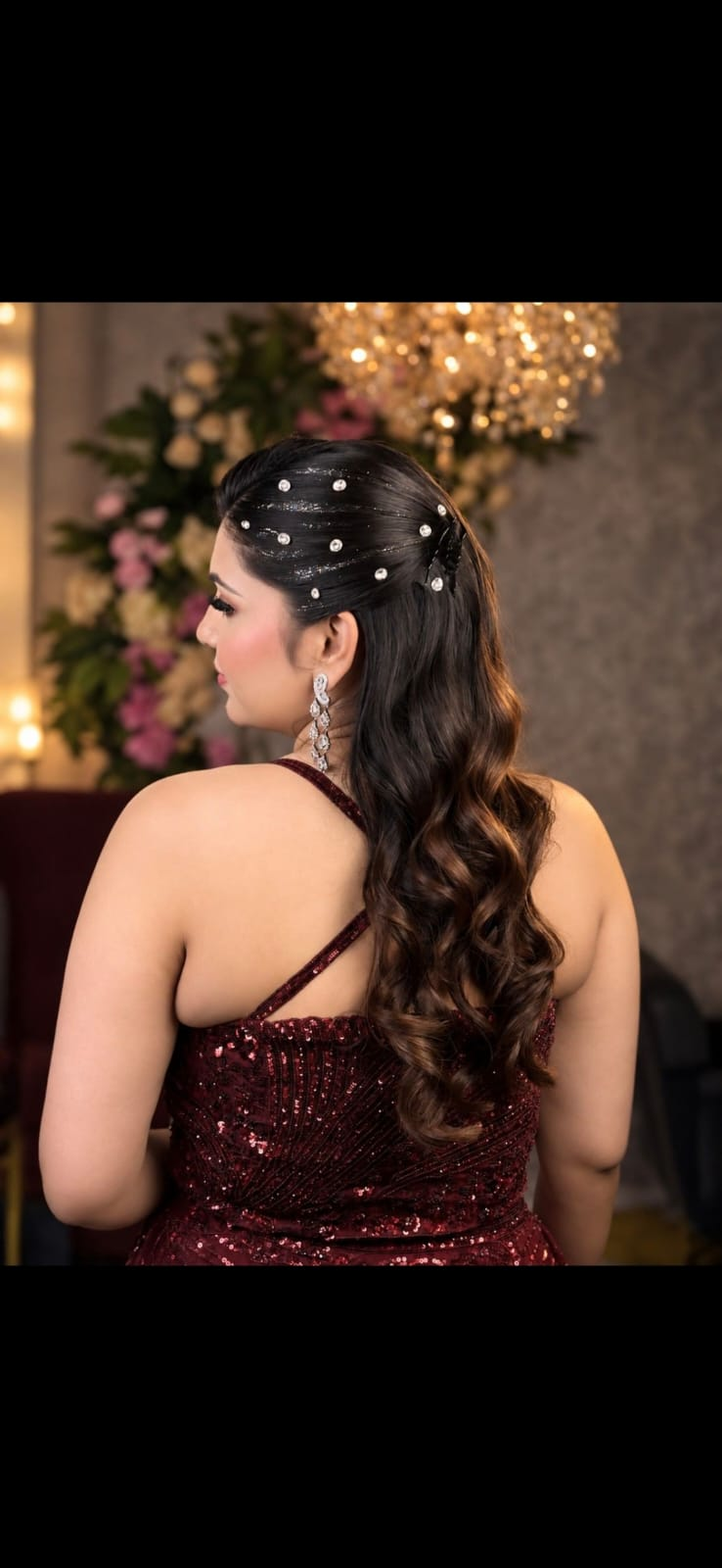 Elegant half-up evening hairstyle with pearl details and flowing waves