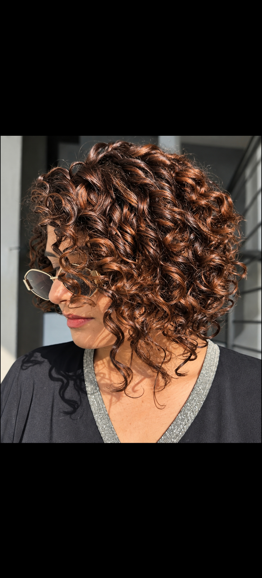 Short copper curls styled with defined texture and shine